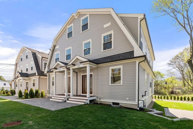 back of property featuring a yard, a shingled roof, and a gambrel roof