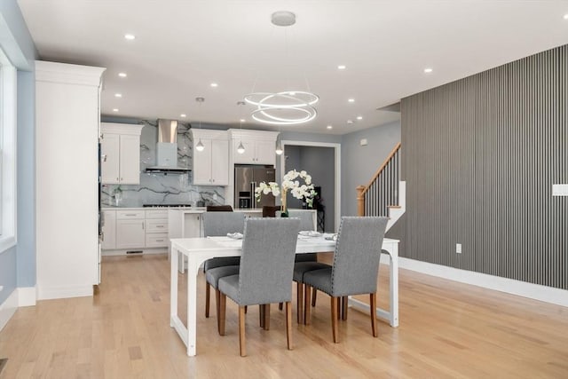 dining space with a notable chandelier, light wood finished floors, recessed lighting, baseboards, and stairway