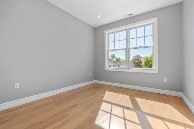 unfurnished room with baseboards, visible vents, and light wood-style flooring