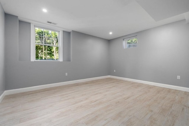 spare room featuring baseboards, visible vents, and light wood-style flooring