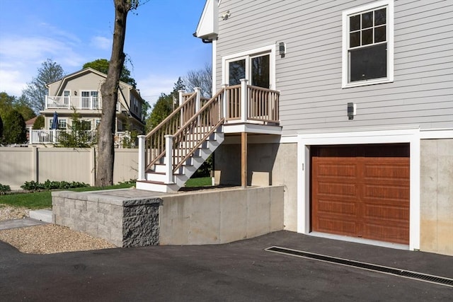 doorway to property with a garage and fence