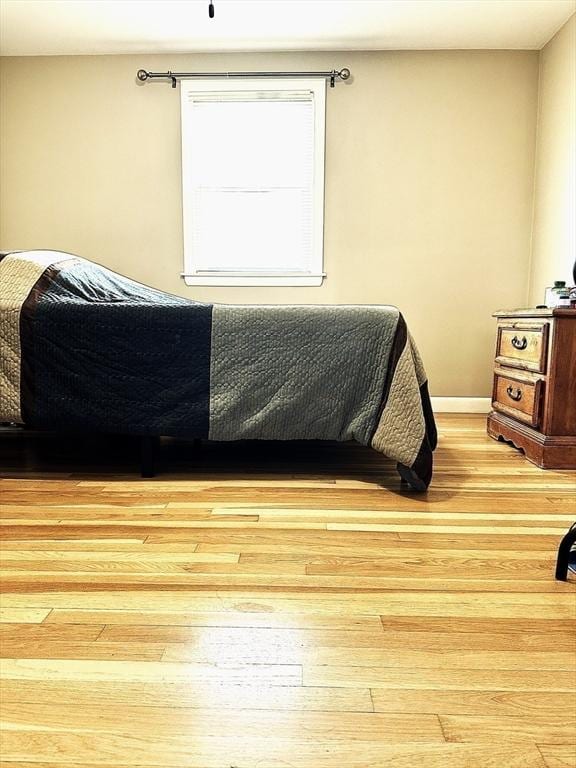 bedroom with light wood finished floors and baseboards