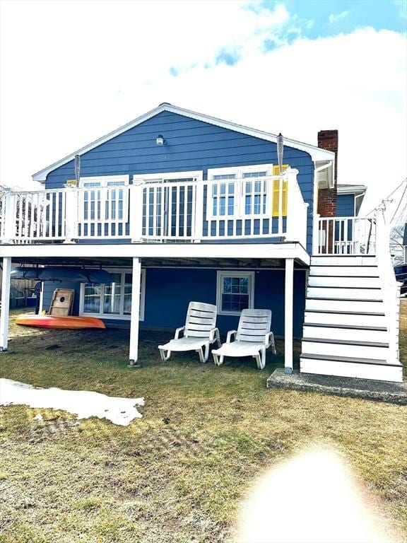 back of property featuring a chimney, stairway, and a wooden deck