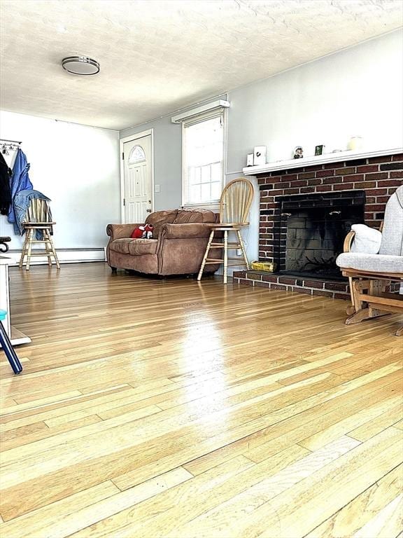 living room featuring a textured ceiling, a brick fireplace, and hardwood / wood-style flooring