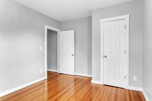 unfurnished bedroom with light wood-style flooring and baseboards