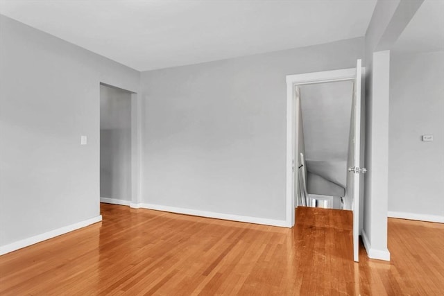 spare room featuring baseboards and wood finished floors