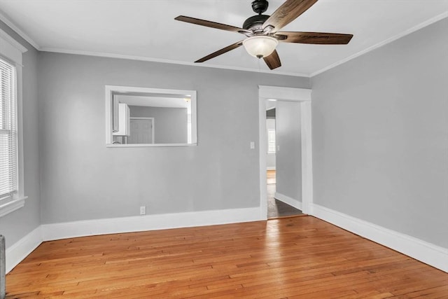 unfurnished room with wood-type flooring, crown molding, and baseboards