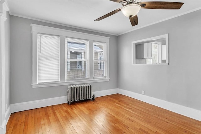 unfurnished room with light wood-type flooring, radiator, crown molding, and baseboards