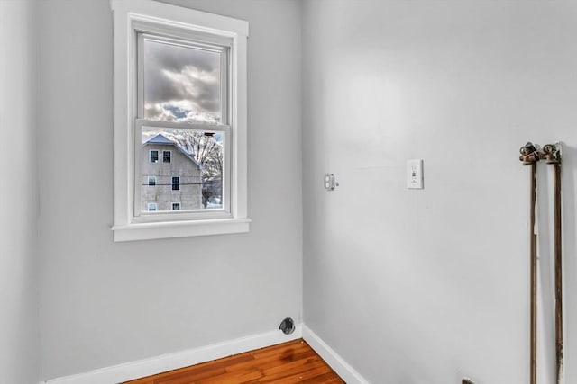 washroom with laundry area, wood finished floors, and baseboards