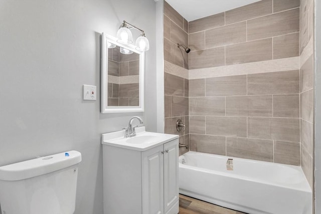 bathroom featuring bathtub / shower combination, vanity, and toilet