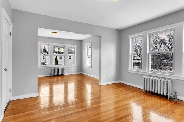 interior space with light wood-type flooring, radiator, and baseboards