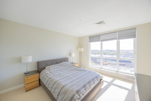 bedroom featuring light colored carpet, baseboards, and visible vents