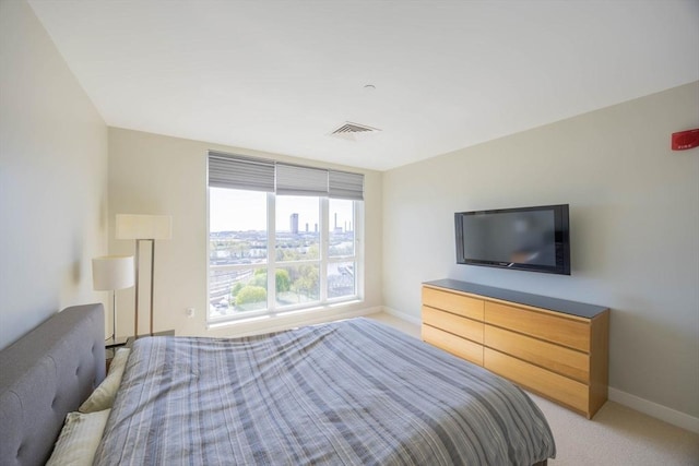 bedroom with baseboards, light carpet, and visible vents