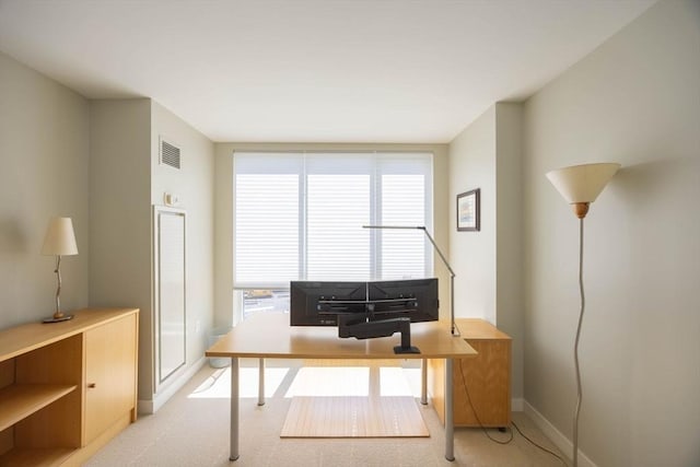 office area featuring light colored carpet, baseboards, and visible vents