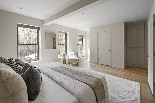bedroom featuring light wood finished floors, beam ceiling, baseboards, and recessed lighting