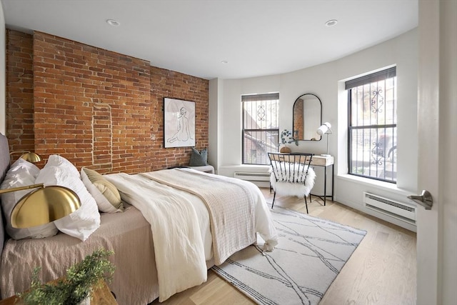 bedroom with a baseboard radiator, brick wall, light wood-type flooring, and recessed lighting