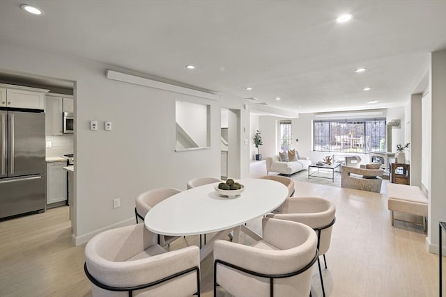 dining area with recessed lighting, light wood-style flooring, and baseboards