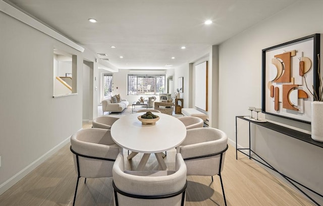 dining room with light wood-style flooring, recessed lighting, and baseboards