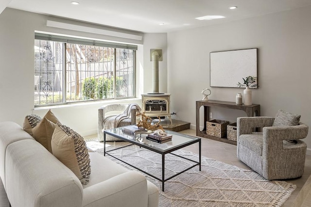 living room featuring recessed lighting, a wood stove, and light wood-style floors