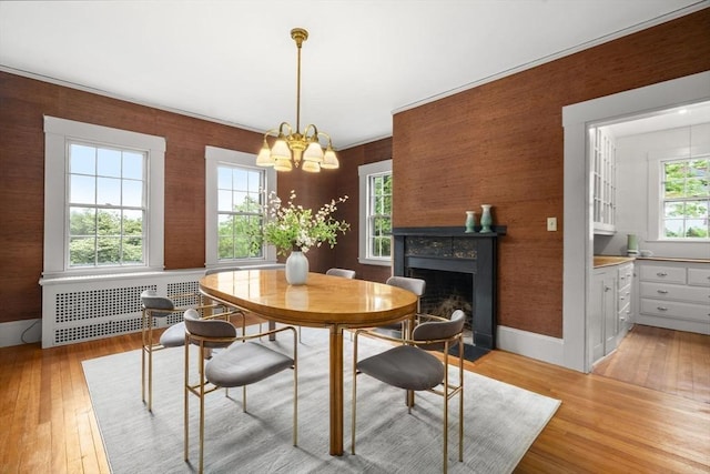 33 Wellington Ln, Belmont, MA 02478 - dining room featuring radiator heating unit, light wood finished floors, a chandelier, a fireplace with flush hearth, and baseboards