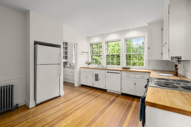 33 Wellington Ln, Belmont, MA 02478 - kitchen featuring white appliances, radiator, light wood-style floors, and white cabinets