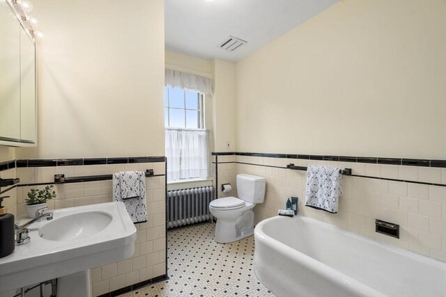 33 Wellington Ln, Belmont, MA 02478 - full bath featuring radiator, tile walls, a wainscoted wall, a tub, and toilet