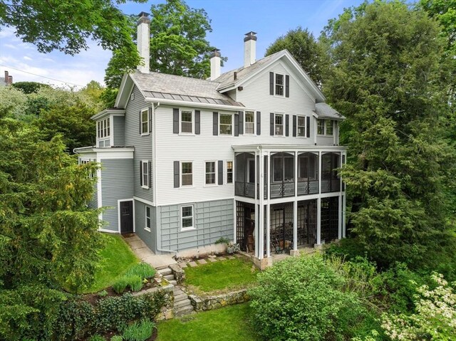 33 Wellington Ln, Belmont, MA 02478 - rear view of property with a standing seam roof, a sunroom, a chimney, and metal roof