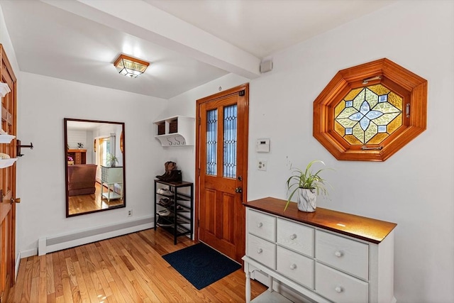 foyer featuring light wood finished floors, baseboard heating, and beam ceiling