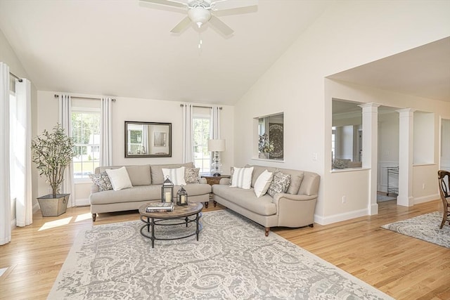 living room with light hardwood / wood-style floors, high vaulted ceiling, ornate columns, and ceiling fan