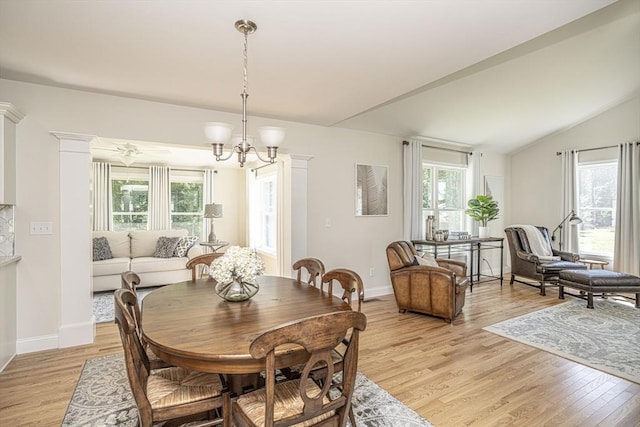 dining space with lofted ceiling, a healthy amount of sunlight, light hardwood / wood-style floors, and a notable chandelier