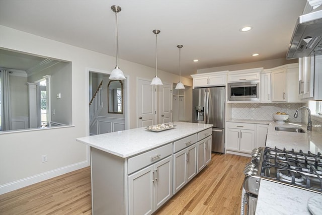 kitchen with extractor fan, a kitchen island, decorative light fixtures, stainless steel appliances, and sink