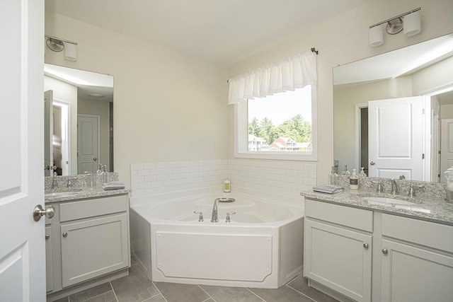 bathroom with a bathing tub, tile patterned floors, and vanity