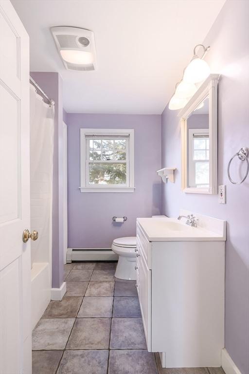 bathroom with toilet, a baseboard heating unit, a wealth of natural light, and vanity