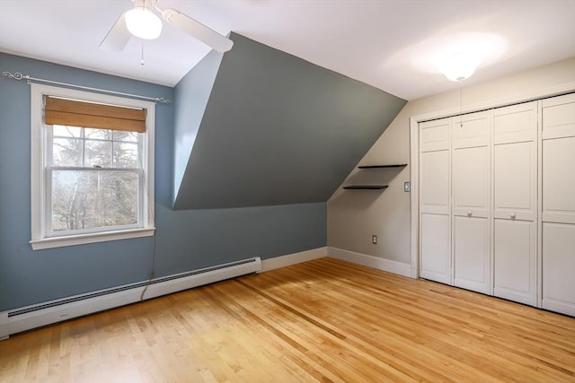 bonus room featuring a baseboard radiator, vaulted ceiling, ceiling fan, light wood-type flooring, and baseboards