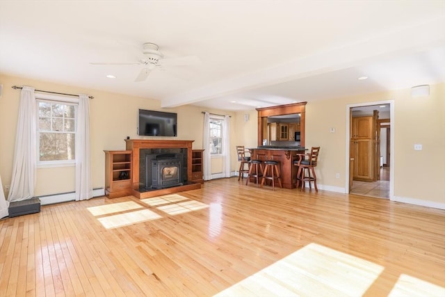 living room featuring light wood-type flooring, plenty of natural light, baseboards, and ceiling fan