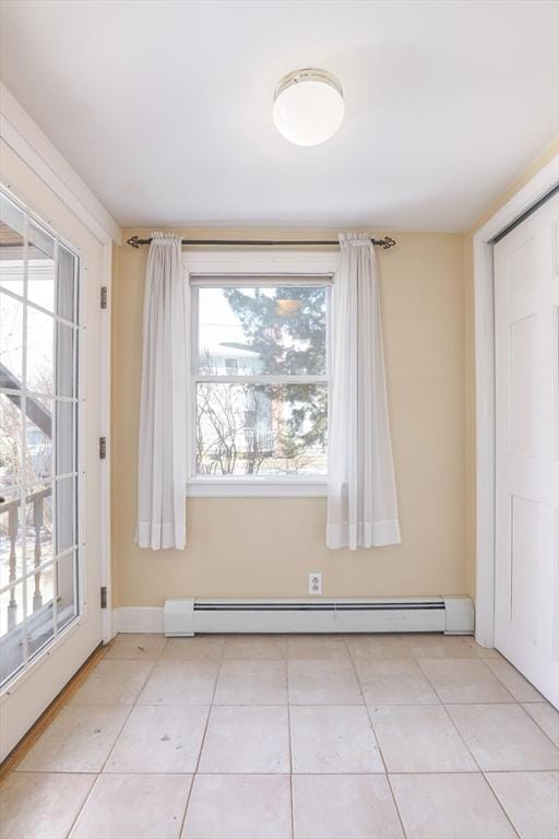 unfurnished room featuring light tile patterned floors, baseboards, and baseboard heating