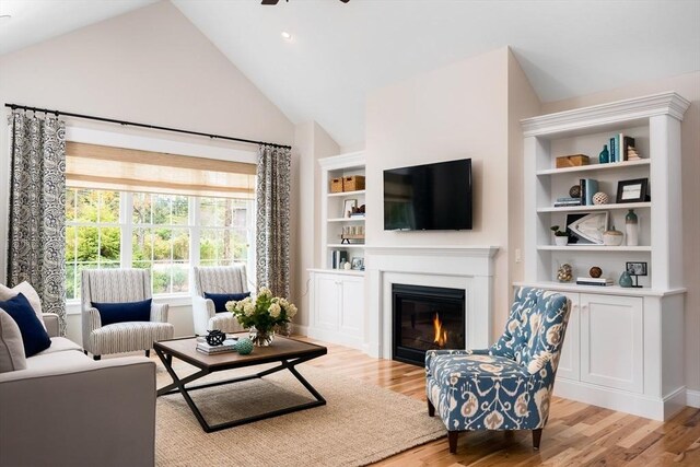 living room featuring high vaulted ceiling, light hardwood / wood-style flooring, and ceiling fan