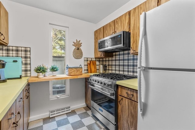 kitchen with backsplash and appliances with stainless steel finishes