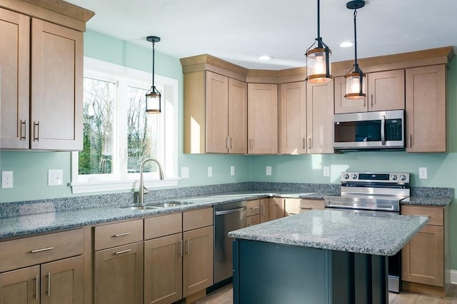 kitchen featuring light stone countertops, sink, stainless steel appliances, pendant lighting, and a kitchen island