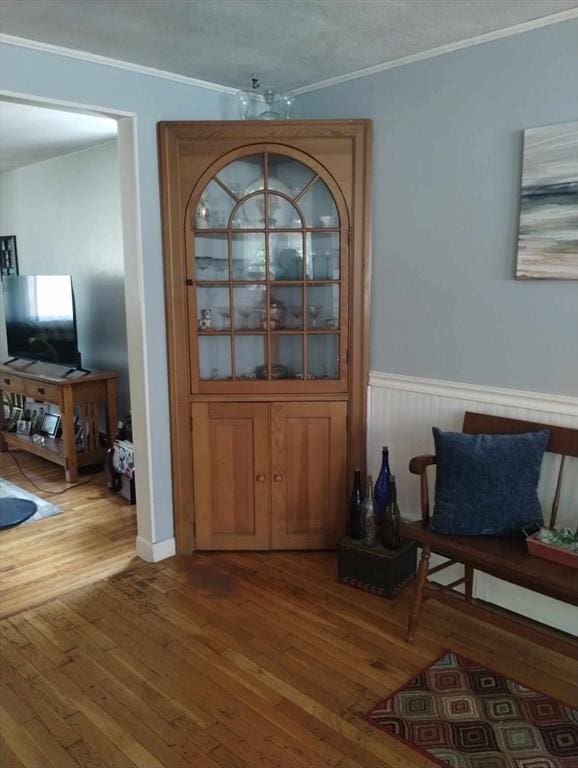 entrance foyer featuring hardwood / wood-style flooring, crown molding, and a textured ceiling