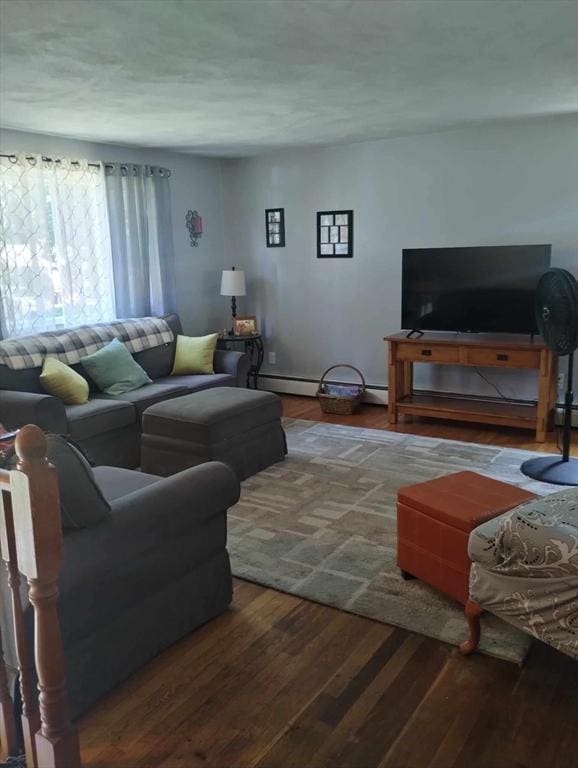 living room with baseboard heating and wood-type flooring