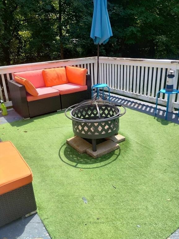 view of yard with a wooden deck and an outdoor living space with a fire pit