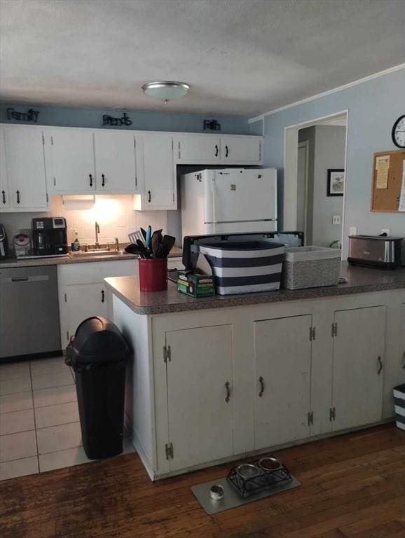 kitchen featuring sink, white cabinets, white refrigerator, stainless steel dishwasher, and dark wood-type flooring