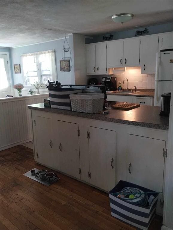 kitchen featuring dark hardwood / wood-style floors, sink, white cabinets, decorative backsplash, and white fridge