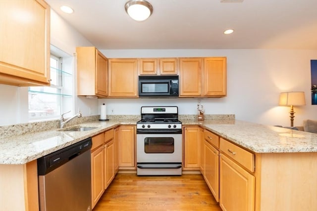 kitchen featuring sink, light brown cabinets, stainless steel appliances, kitchen peninsula, and light wood-type flooring