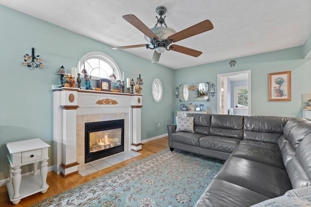 living room with a fireplace, a wealth of natural light, light hardwood / wood-style floors, and ceiling fan