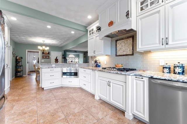 kitchen featuring decorative light fixtures, a notable chandelier, kitchen peninsula, white cabinetry, and stainless steel appliances