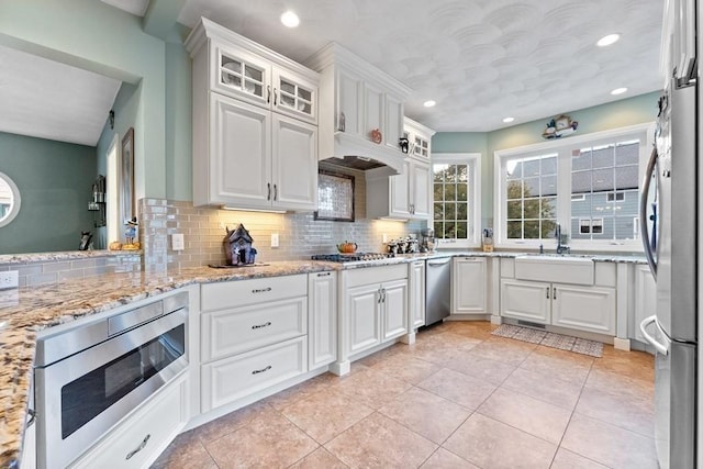 kitchen with tasteful backsplash, appliances with stainless steel finishes, and white cabinetry