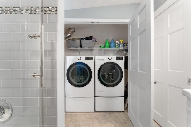 laundry area featuring washer and clothes dryer and light tile patterned flooring