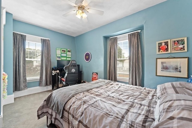 carpeted bedroom featuring ceiling fan and multiple windows